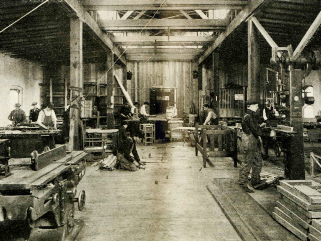Students work at different stations in a wood shop classroom.