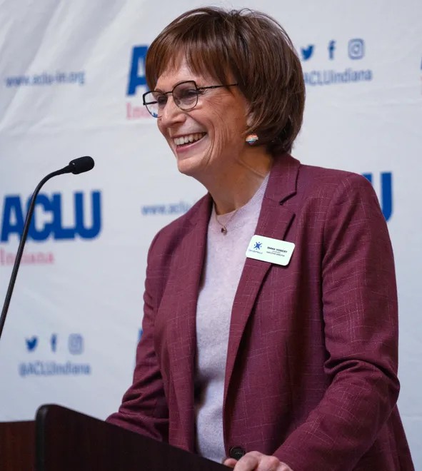 A woman stands at a podium.
