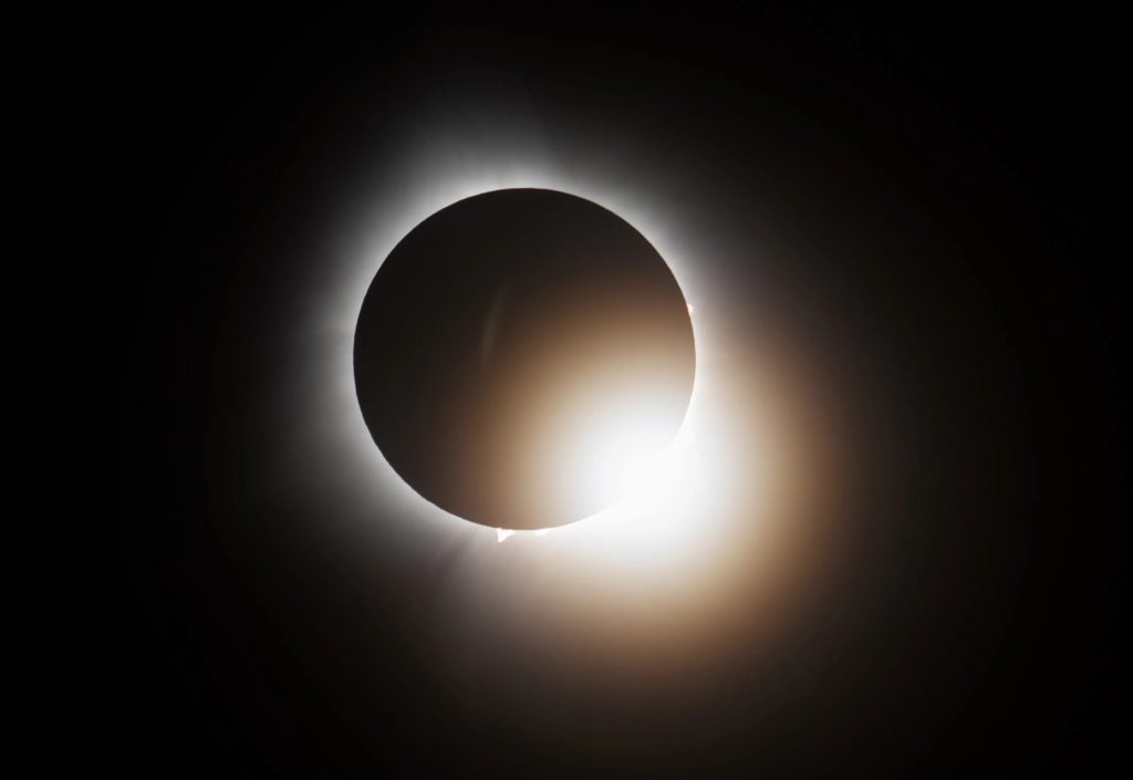 Close up view of a solar eclipse. The sun shows around the moon as a halo.