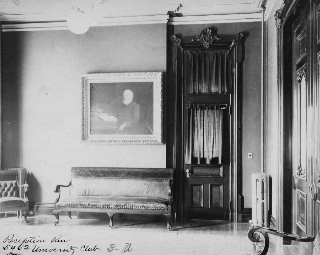 A reception room with a chair and sofa lining one wall. A painting of Benjamin Harrison hangs on the wall above the sofa.