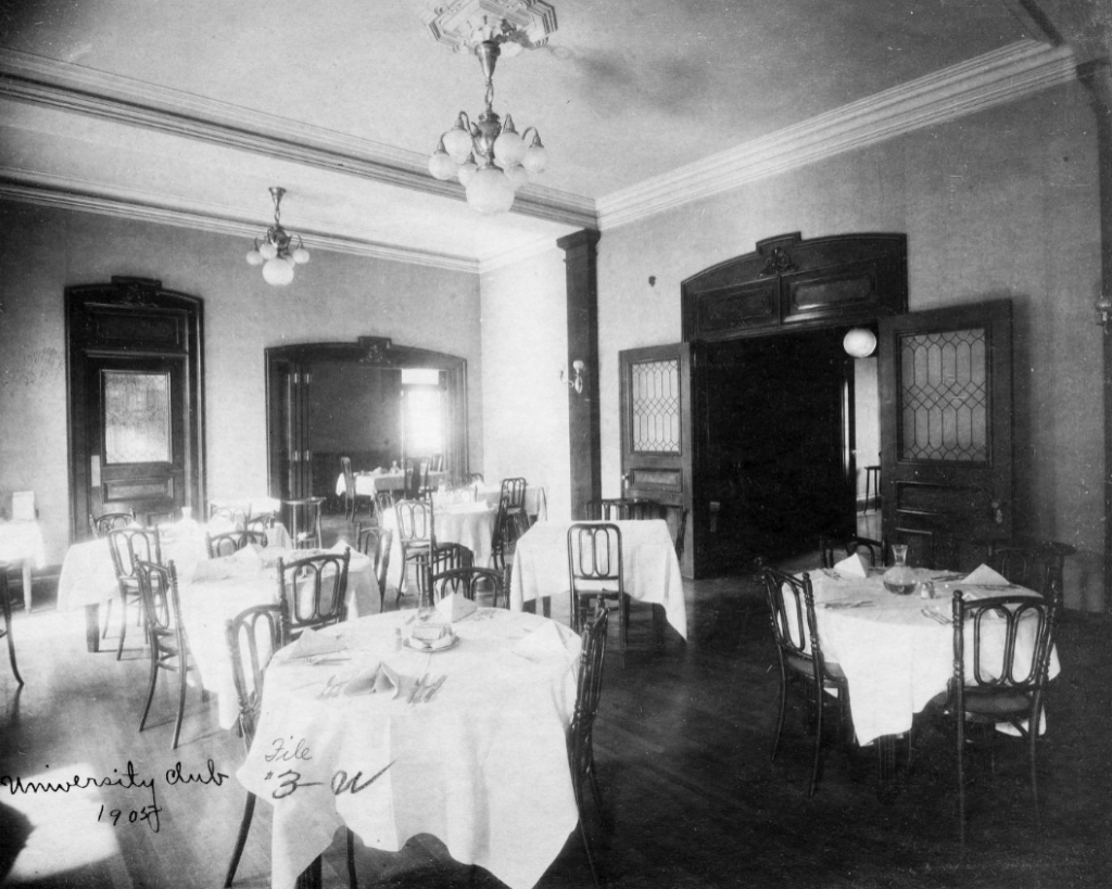 A large dining room filled with several cloth-covered tables.