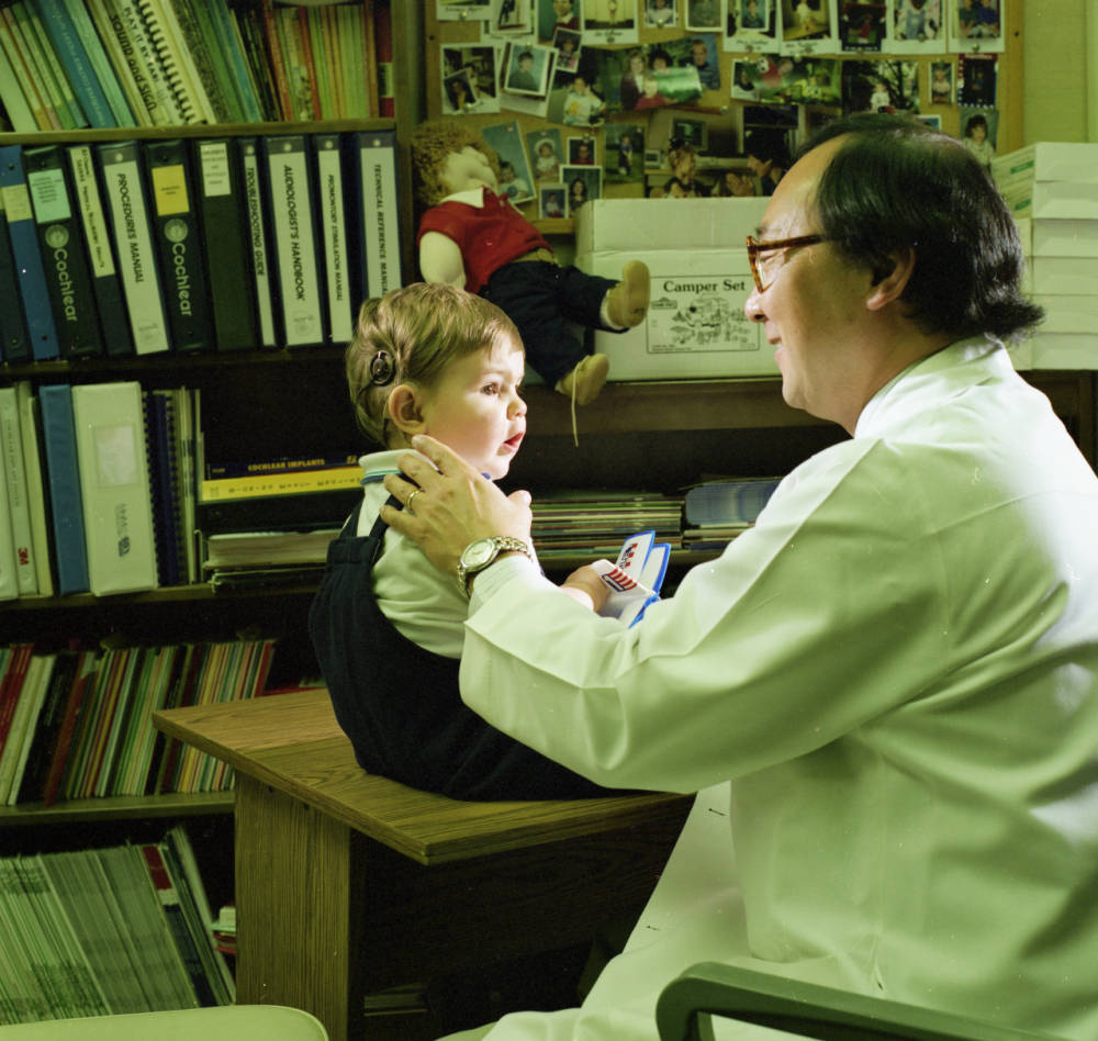 Dr. Miyamoto examines a young child with a cochlear implant.