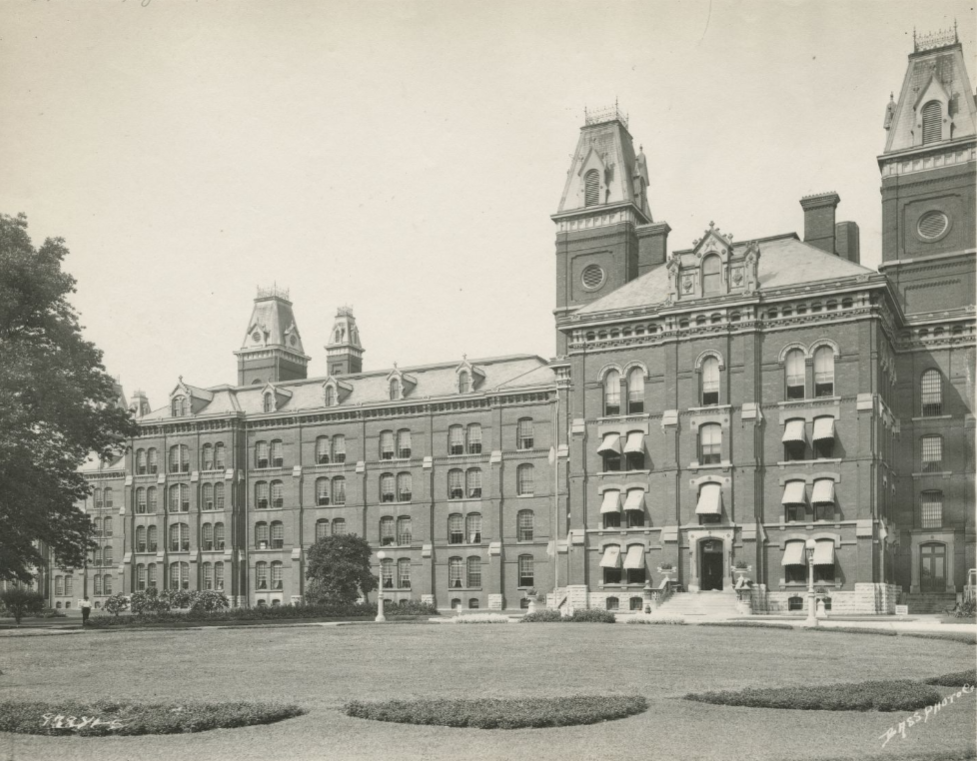 A large multi-story brick building with several decorative steeples.