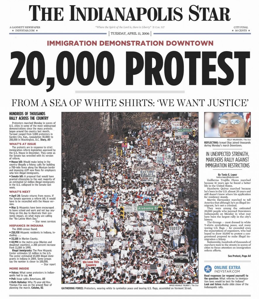 Front page of The Indianapolis Star dated April 11, 2006, featuring the headline “20,000 Protest” above a large photograph of a massive downtown immigration demonstration. Thousands of marchers in white shirts fill city streets carrying signs and U.S. flags.