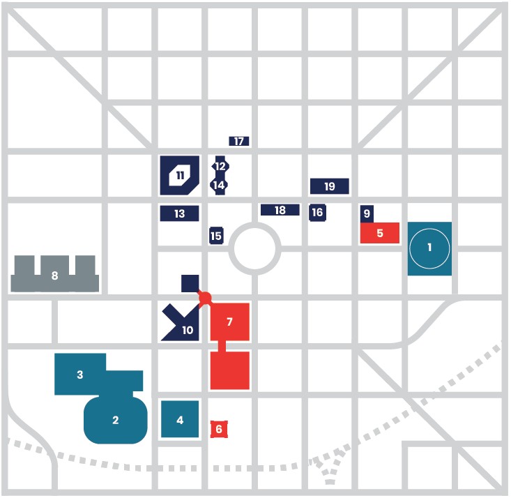 Simplified site map showing a street grid with numbered development areas. Color-coded blocks mark locations 1–19, including teal, navy, red, and gray buildings, roads, a roundabout, and a dotted route crossing the lower portion of the map.