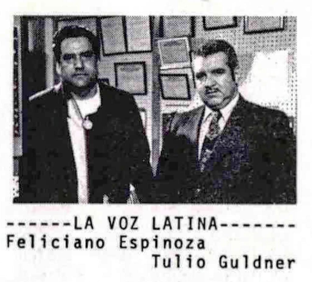 Black-and-white photograph showing two people standing side by side in an office or newsroom. Beneath the image is the title “La Voz Latina” and the names “Feliciano Espinoza” and “Tulio Guldner.”