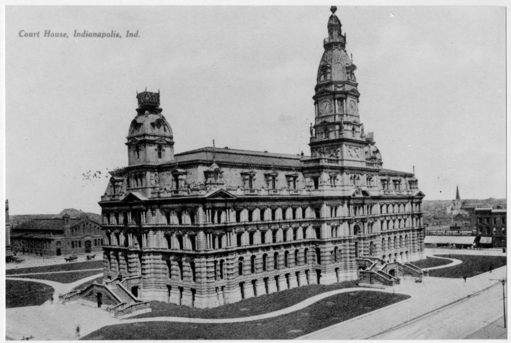 Historic postcard view of the Marion County Courthouse in Indianapolis, Indiana, showing the large stone courthouse with a central clock tower, domed corner tower, surrounding lawns, and winding walkways.