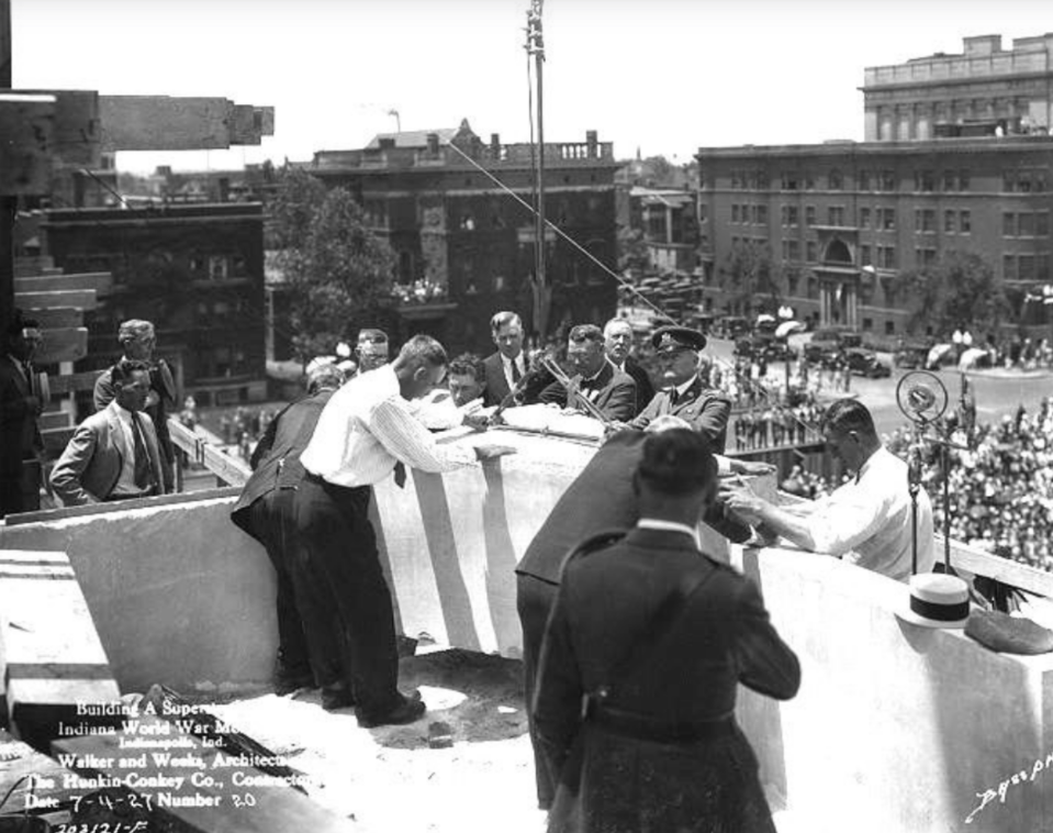 Historic black-and-white photograph showing a ceremonial event taking place on the upper level of the Indiana World War Memorial during construction.