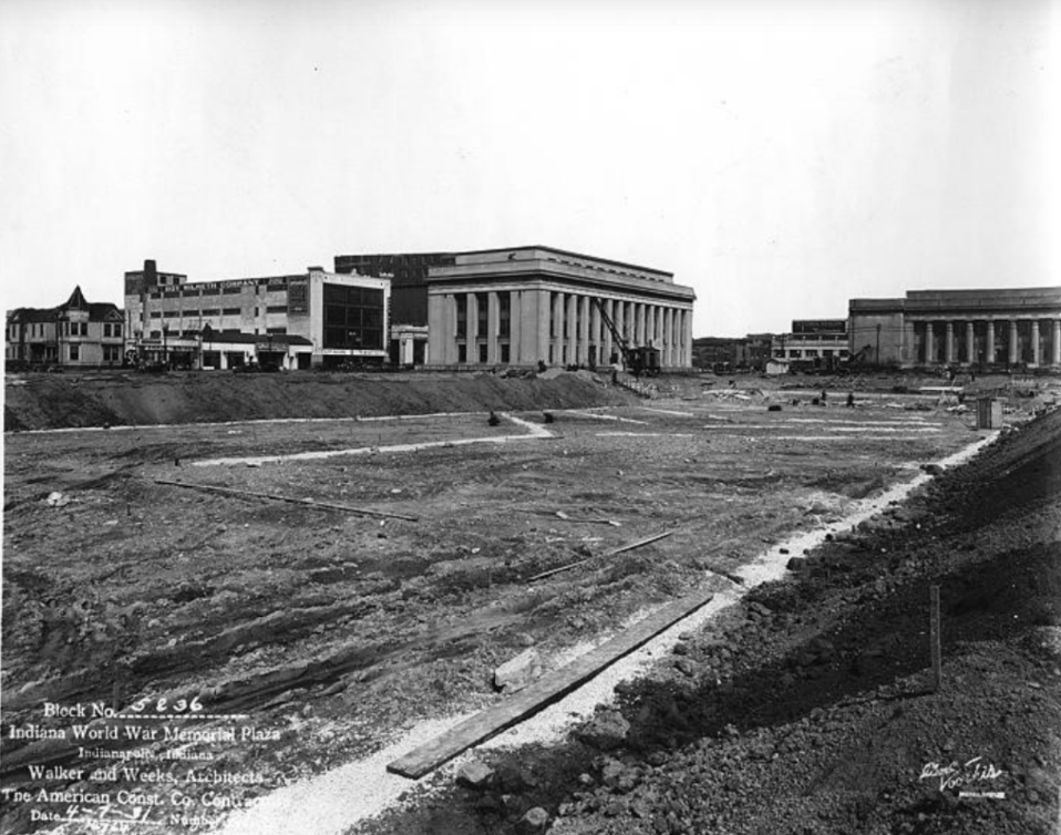 Historic black-and-white photograph showing construction of Block No. 5 of the Indiana World War Memorial Plaza. The foreground consists of an excavated construction site with rough earth, trenches, and early layout markings for future pathways and landscape features.