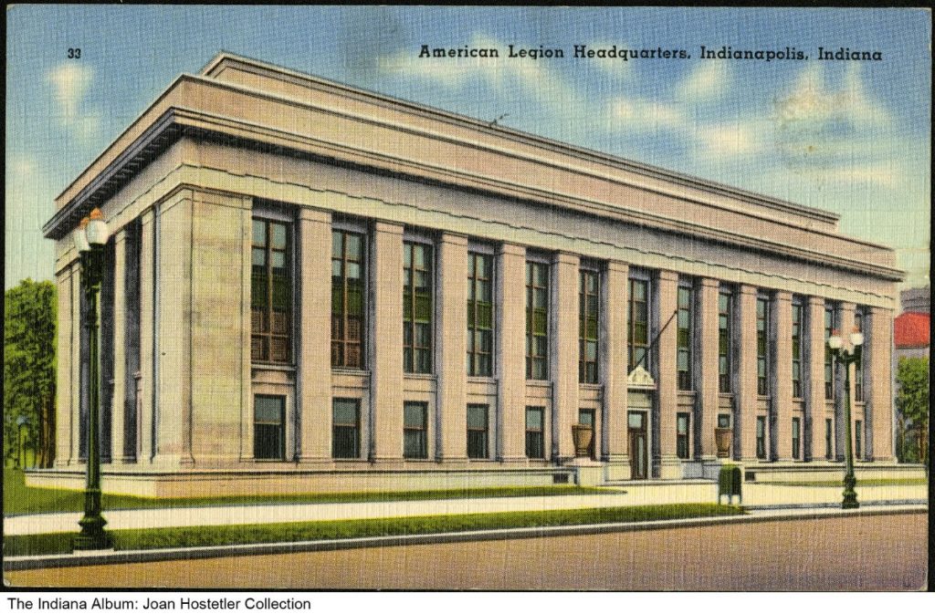 Color postcard depicting the American Legion Headquarters in Indianapolis, Indiana. The large neoclassical building is constructed of light-colored stone and features a long façade lined with tall rectangular columns and narrow multi-story windows.