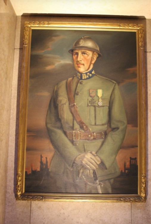 Painting of a soldier. The painting has a gold frame and hangs on a marble wall.